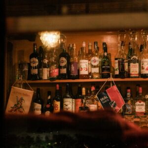 a shelf filled with bottles of alcohol and liquor glasses